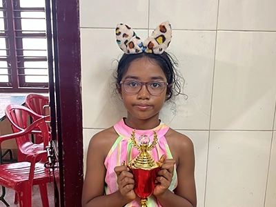 Joshana receiving recognition for her performance in a competitive chess tournament.