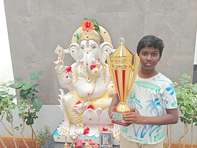 Kanishka Chatura celebrating victory with a trophy at a competitive chess event.