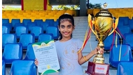 Young chess players proudly holding trophies after winning tournament matches.